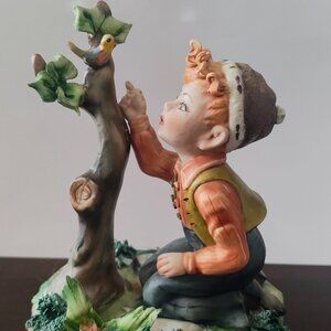BOY LOOKING AT BIRD FIGURINE MADE IN ITALY